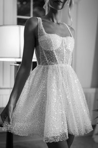 Black and white image of beaded tulle bridal mini dress with sheer corset bodice and flared mini skirt