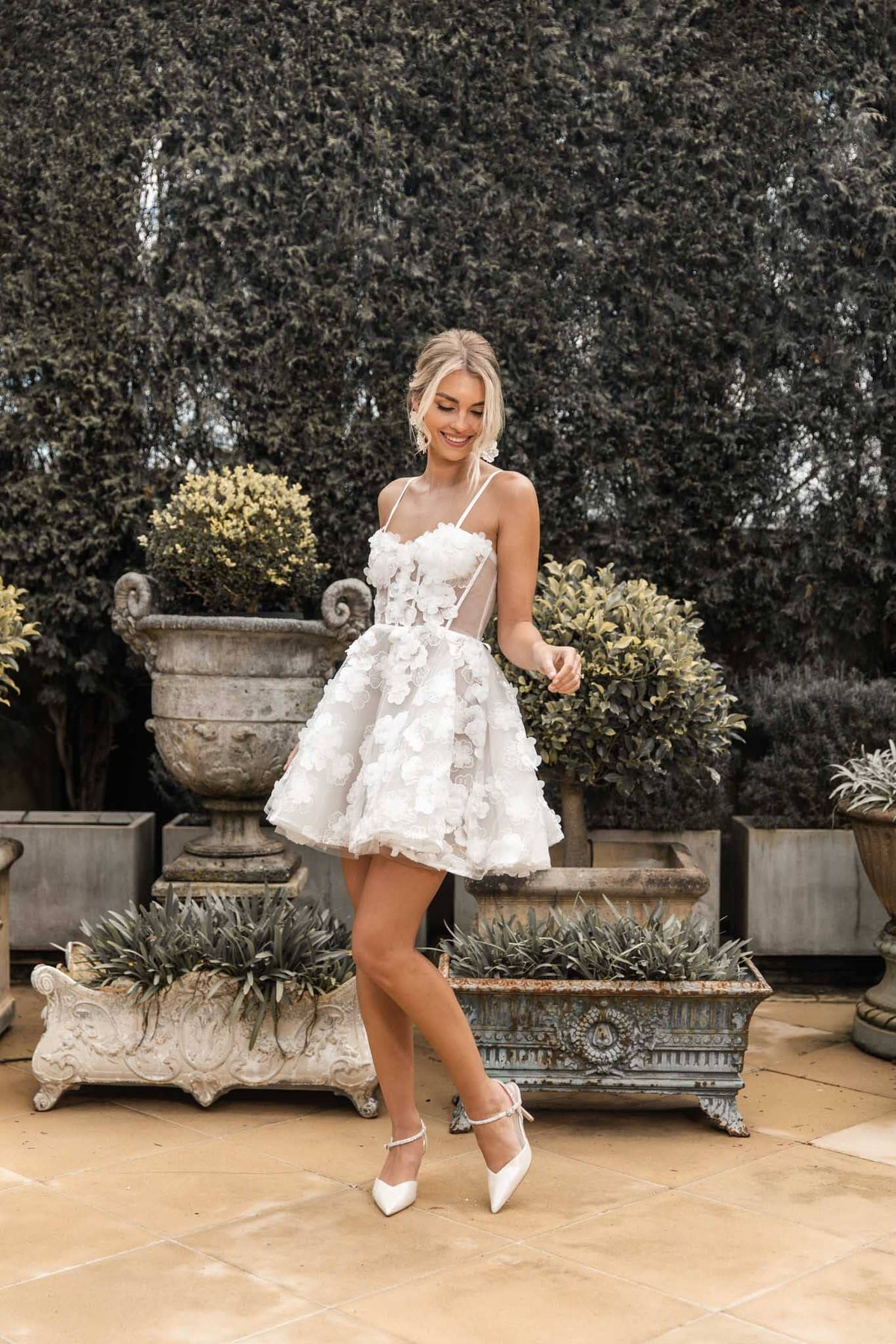 Dancing bride-to-be in white 3D flower mini dress with flared skirt