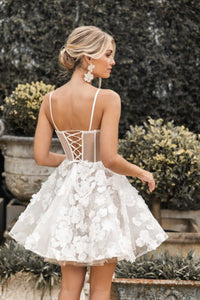 Lace up back design of white mini dress featuring hand-sewn 3D flower appliques over flower lace, sheer corset bodice, layered tulle puffy skirt and thin shoulder straps