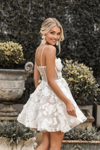 Side image of white mini dress featuring hand-sewn 3D flower appliques over flower lace, layered tulle puffy skirt, thin shoulder straps and lace up back